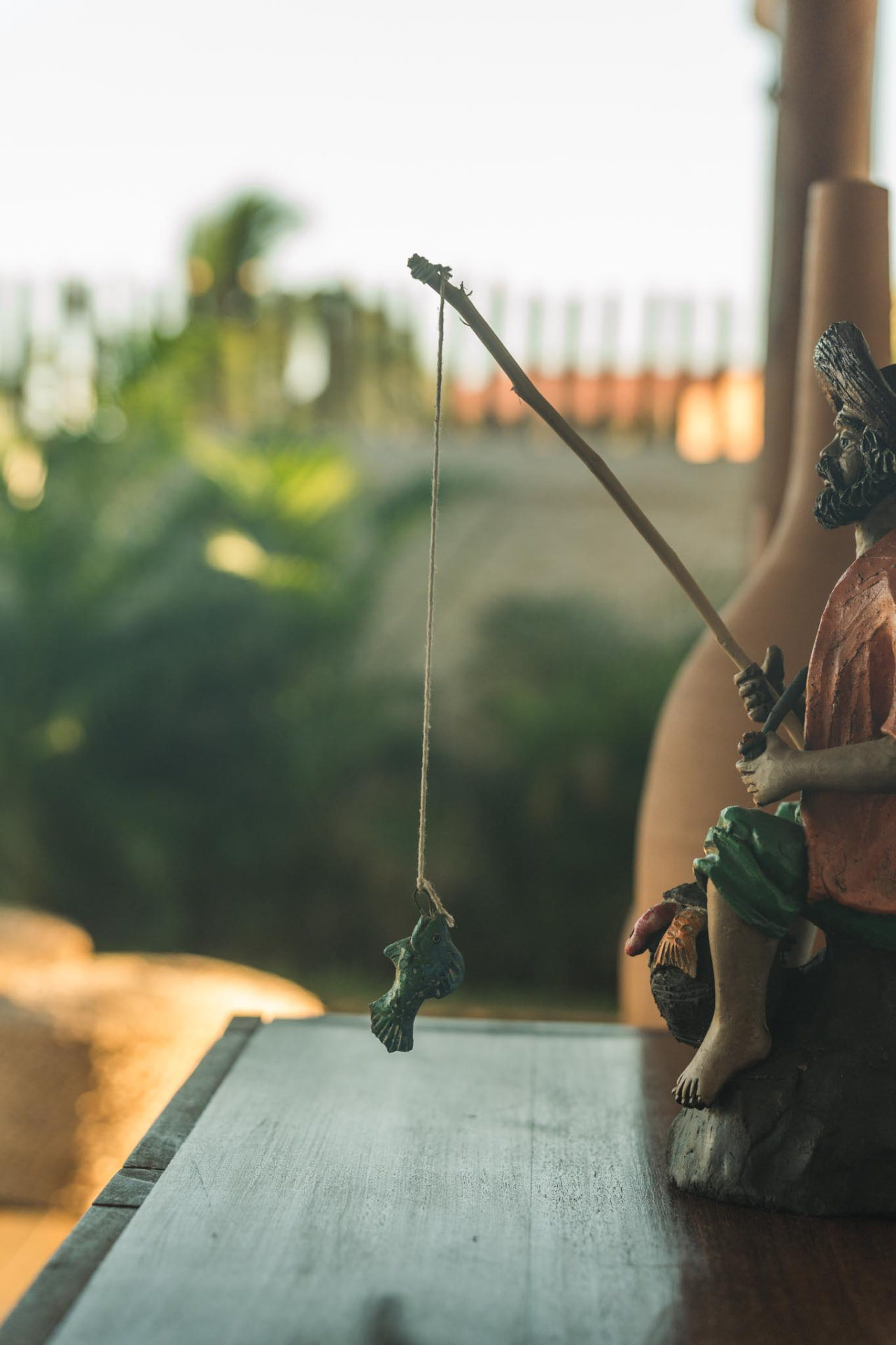 Escultura artesanal de pescador entre a decoração da casa