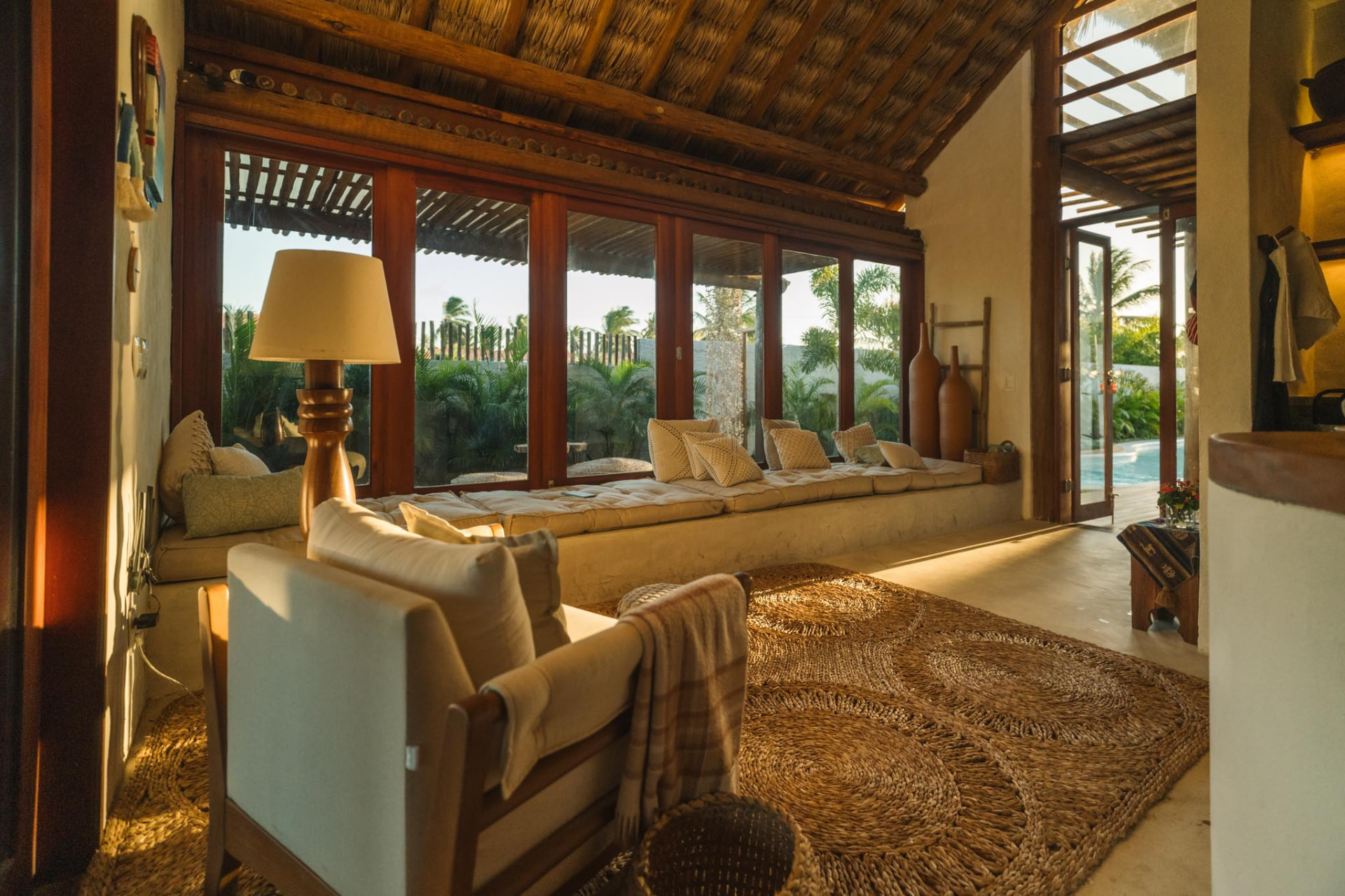 Sala de estar integrada ao jardim e à piscina ao fim da tarde